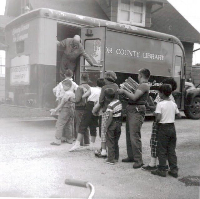 Children in Door Country line up to visit the bookmobile