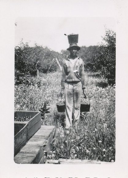 A migrant worker with three pails of cherries at the Fardig Orchard in Ephraim, WI, c. 1930. Photograph courtesy of the Ephraim Historical Foundation.