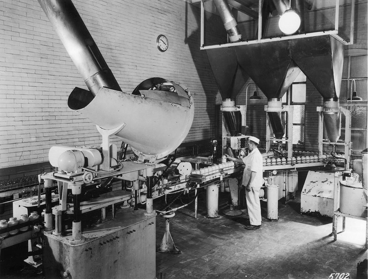 A photograph of the interior of a factory showing a bottling line.
