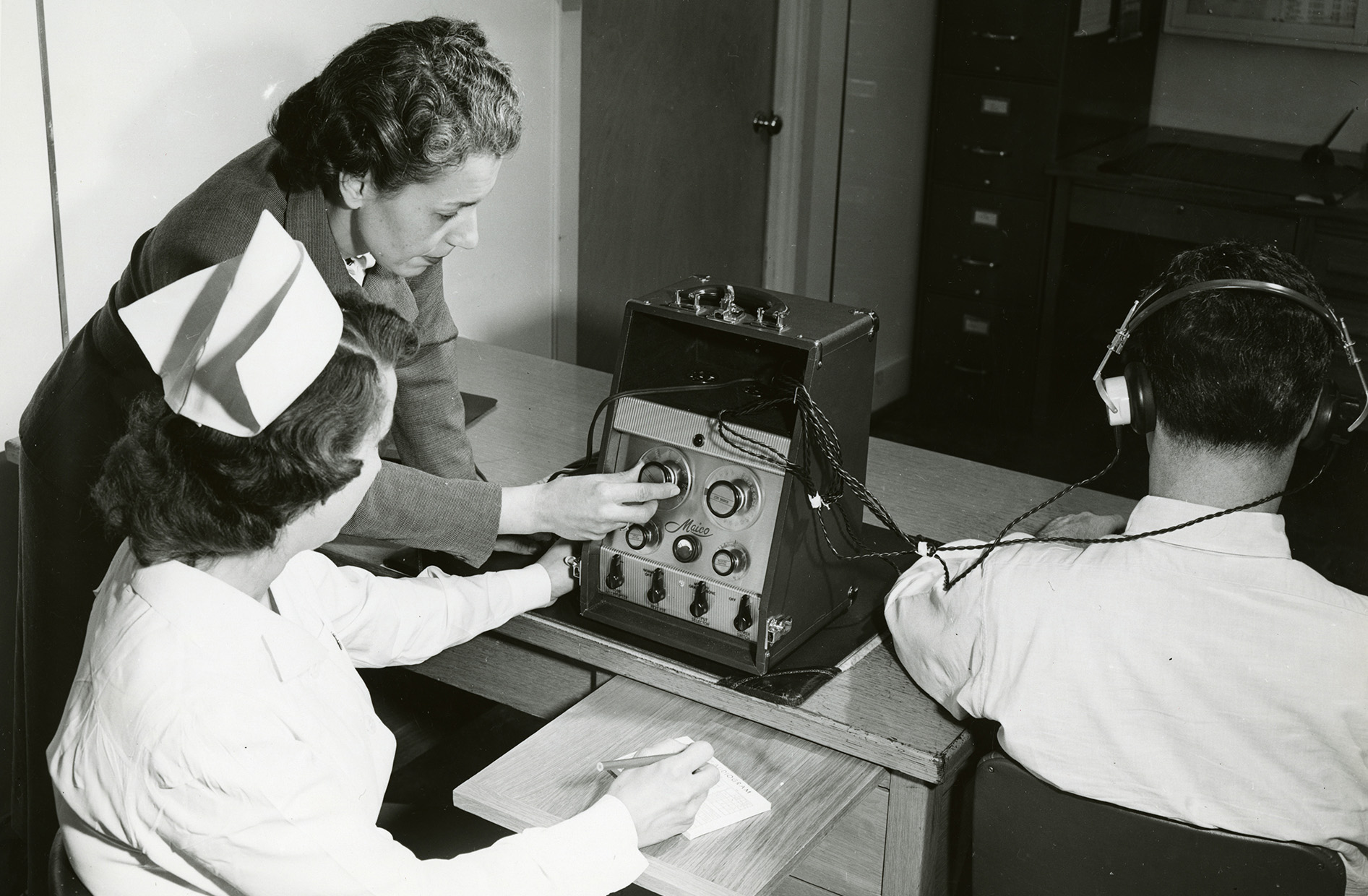 An Employers Mutual Occupational Health Consultant administering a hearing test c. 1960. Photograph courtesy of the Marathon County Historical Society.
