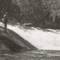 a black and white image of a man fishing in the wolf river