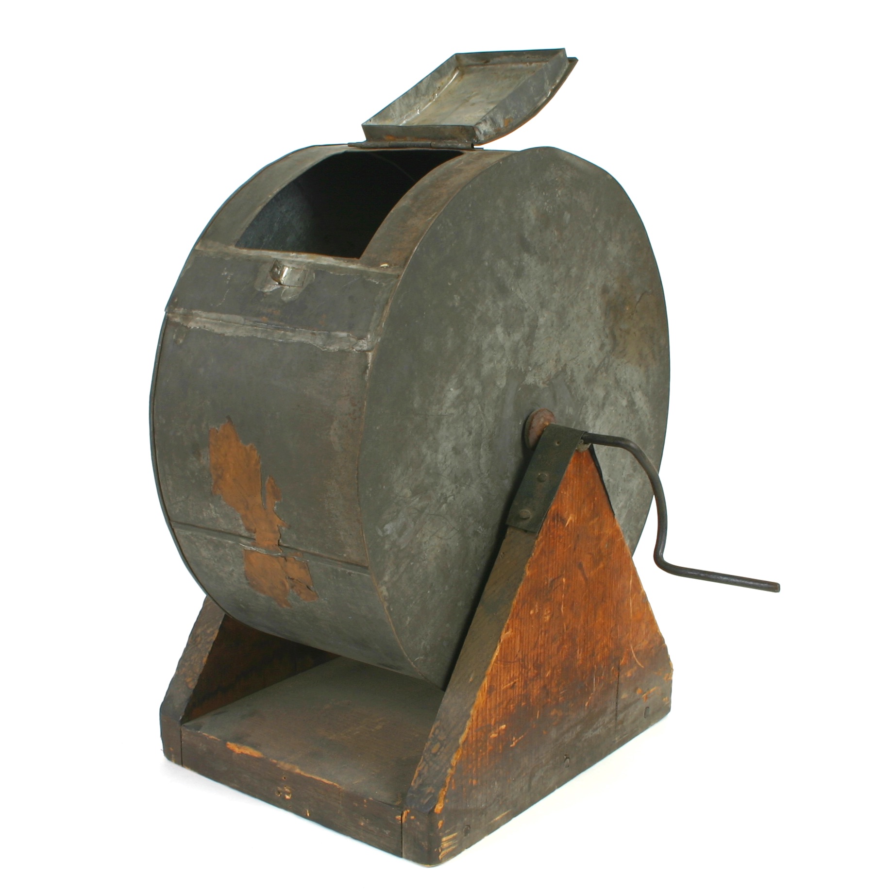 A metal cylinder with a handle for turning and a hatch for selecting items from within, on a stand