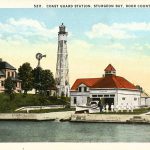 A color postcard showing a lighthouse and lifesaving station in wisconsin.