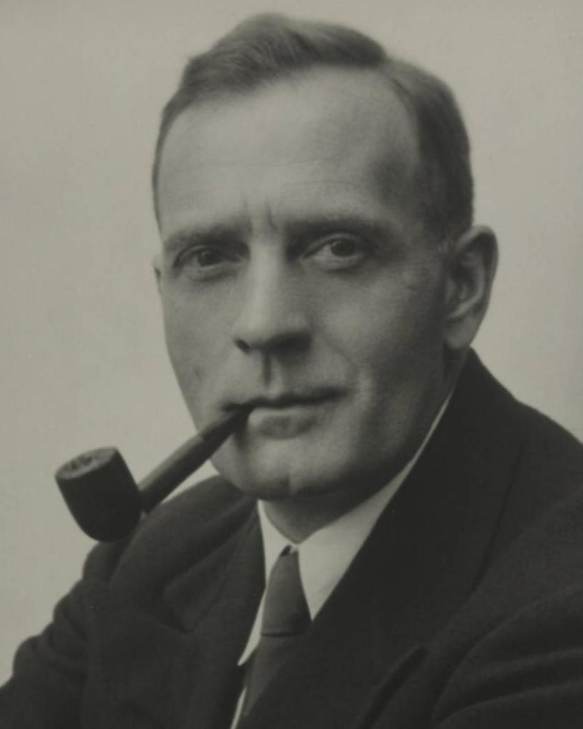 A black and white portrait of Edwin Powell Hubble smoking a pipe