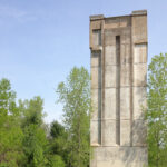 A picture of the Kickapoo Valley Reserve dam tower showing a concrete tower rising nearly 100 feet above a grassy lawn