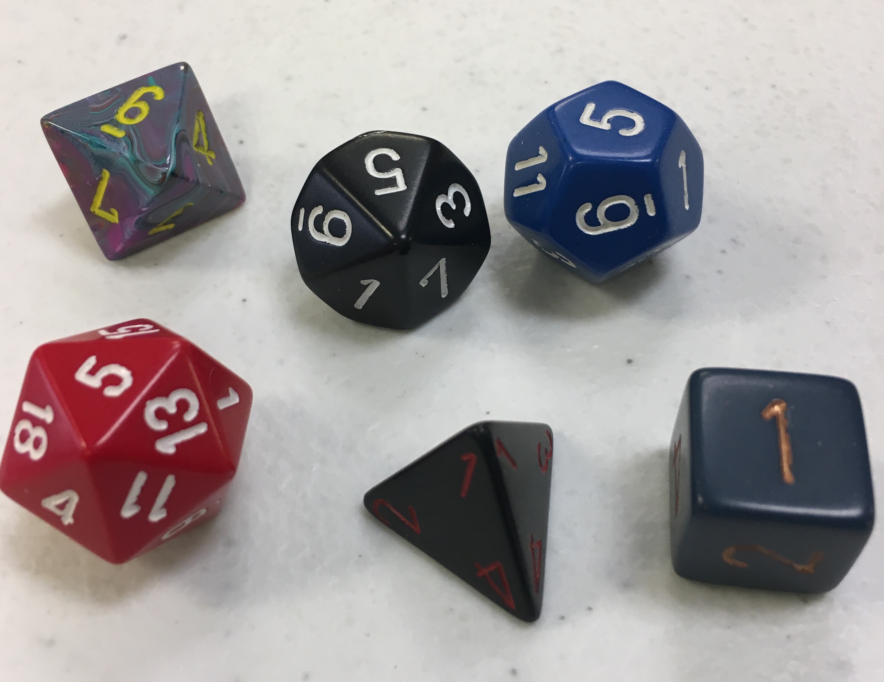 A color photograph showing six types of die in various colors