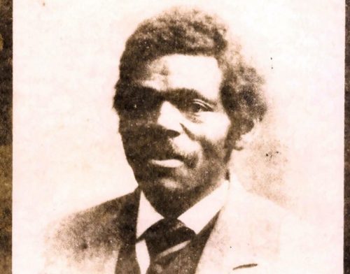 A portrait of James D. Williams showing an African American man wearing a light colored suit, a dark vest, and a dark tie looking at the camera