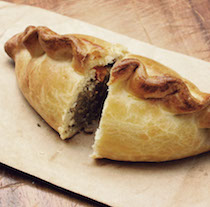 an image of a cut cornish pasty showing the filling and edging