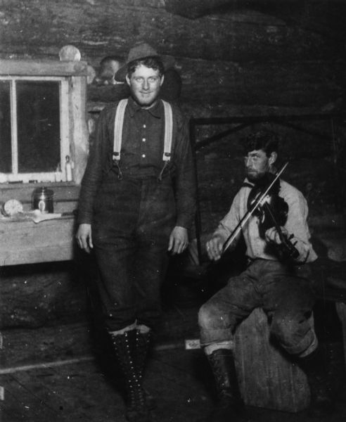 a fiddle player and jig dancer in a lumber camp