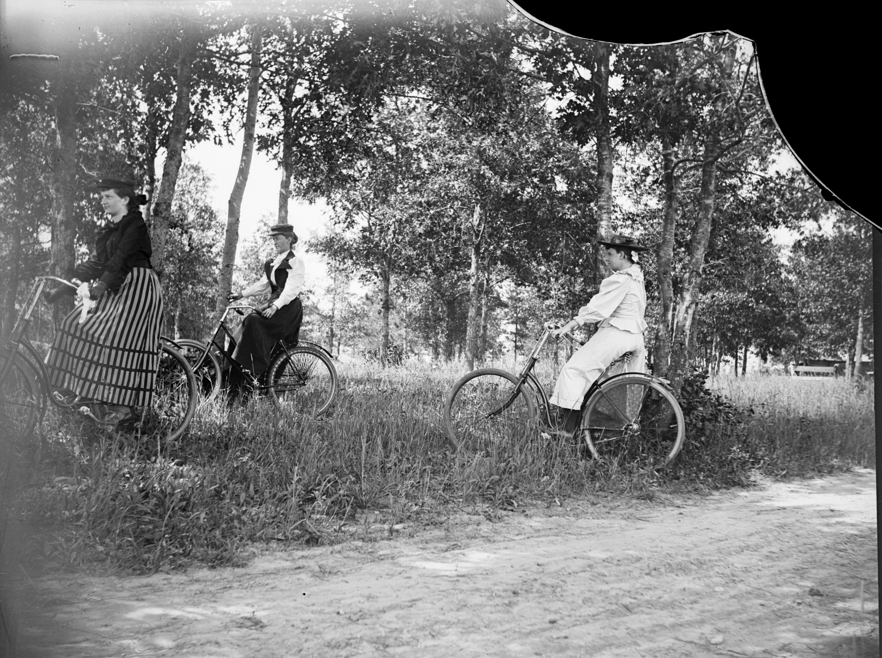 women cyclists beside a dirt road