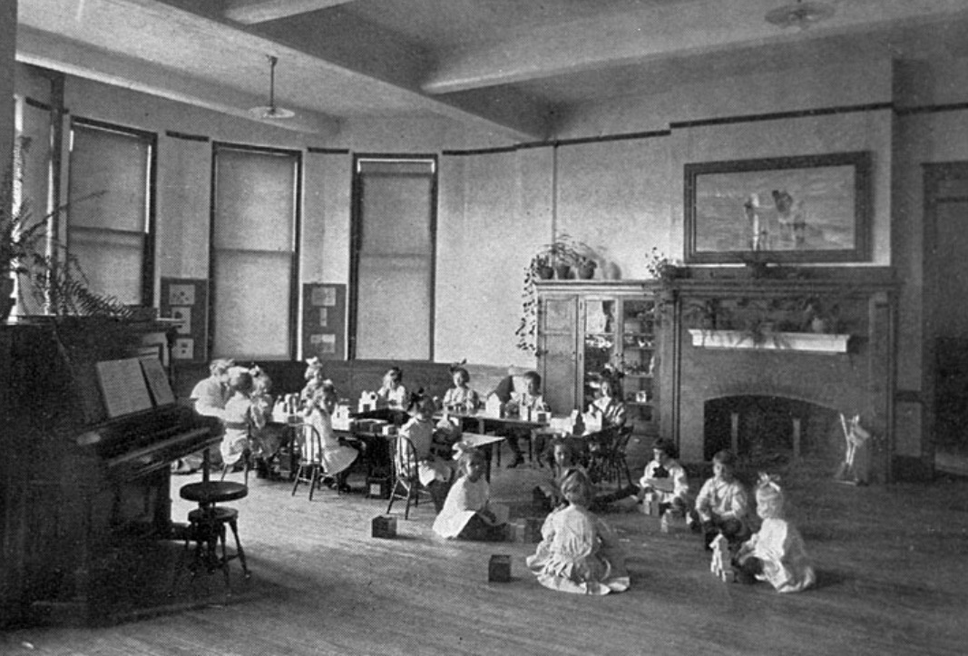 Image of several children sitting before a fireplace playing with toys