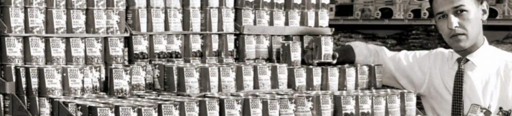 A grocery clerk stocking Jolly Good soda.