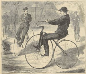 three men ride velocipedes, bicycles with a front wheel that is larger than the back wheel.