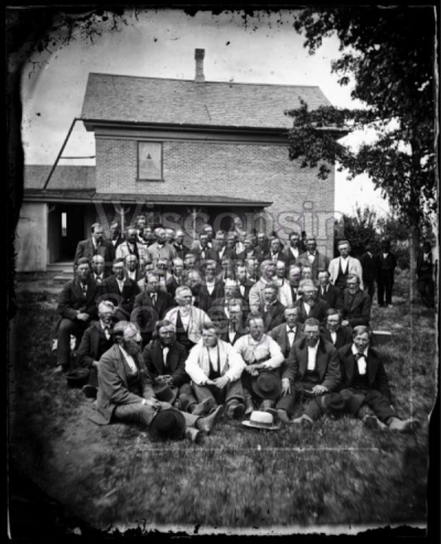 Men sitting outside of the East District Norwegian Synod at the Immanuel Norwegian Evangelical Lutheran Church, c. 1877. Winchester, Wisconsin