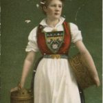 A Norwegian girl in traditional dress holding a basket