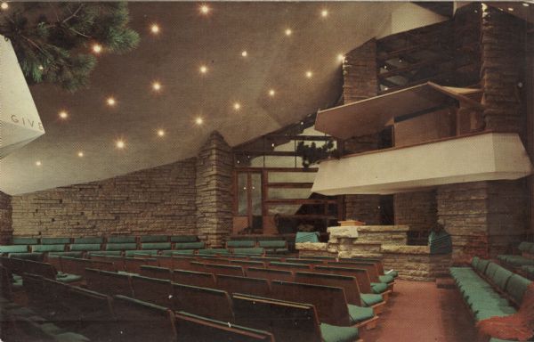 Color photo postcard of the interior of the auditorium of the meeting house, facing the altar.