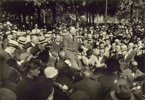 Franklin D. Roosevelt sits on the back of his vehicle amidst a large crowd in Milwaukee in 1932. Wisconsin Historical Society, Image #56977.