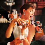 A print ad for Martini & Rossi showing a woman, finely dressed, pouring vermouth into a cordial glass. Two other hands, each holding glasses reach into the photograph.
