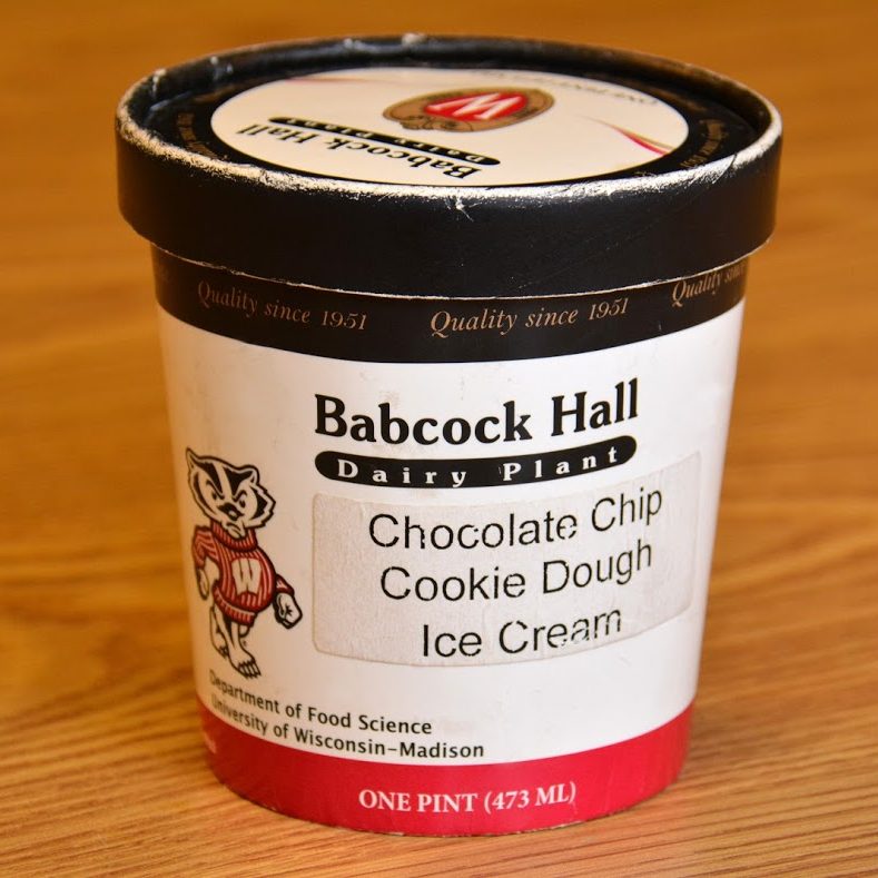 A carboard ice cream carton with the text, “Babcock Hall Dairy Plant, Chocolate Chip Cookie Dough Ice Cream” and an image of UW-Madison mascot Bucky Badger.