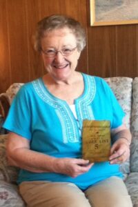 Shirley Beardsley displaying a 5-cent bag of Corn Kinx sold by the Reed family.