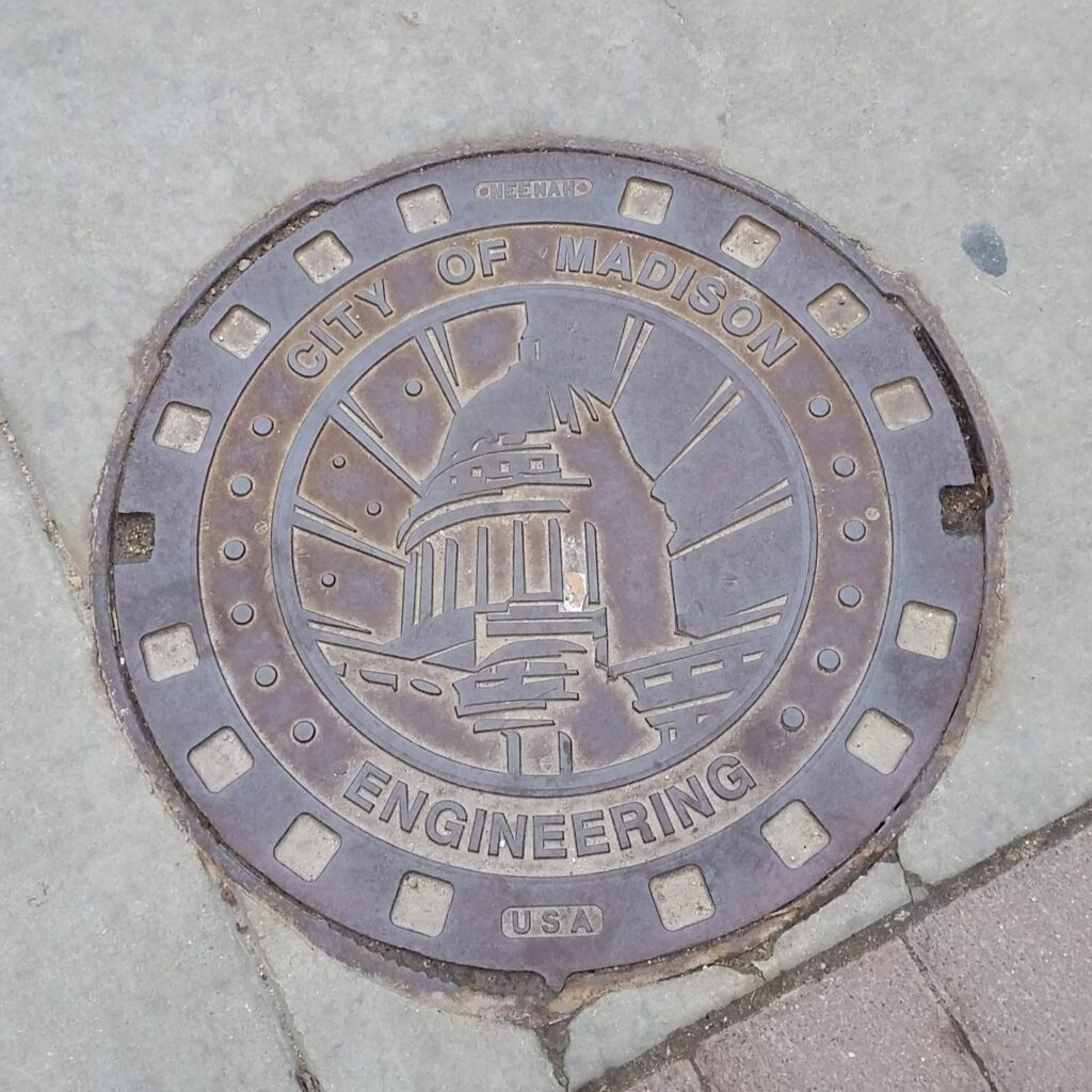 Manhole cover with the image of the Wisconsin Capitol dome.