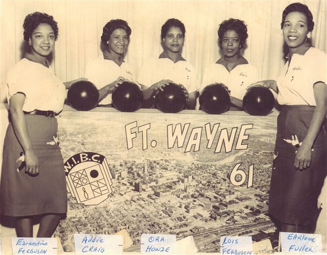 A five women bowling team holding bowling balls behind a sign that reads "Ft. Wayne '61"