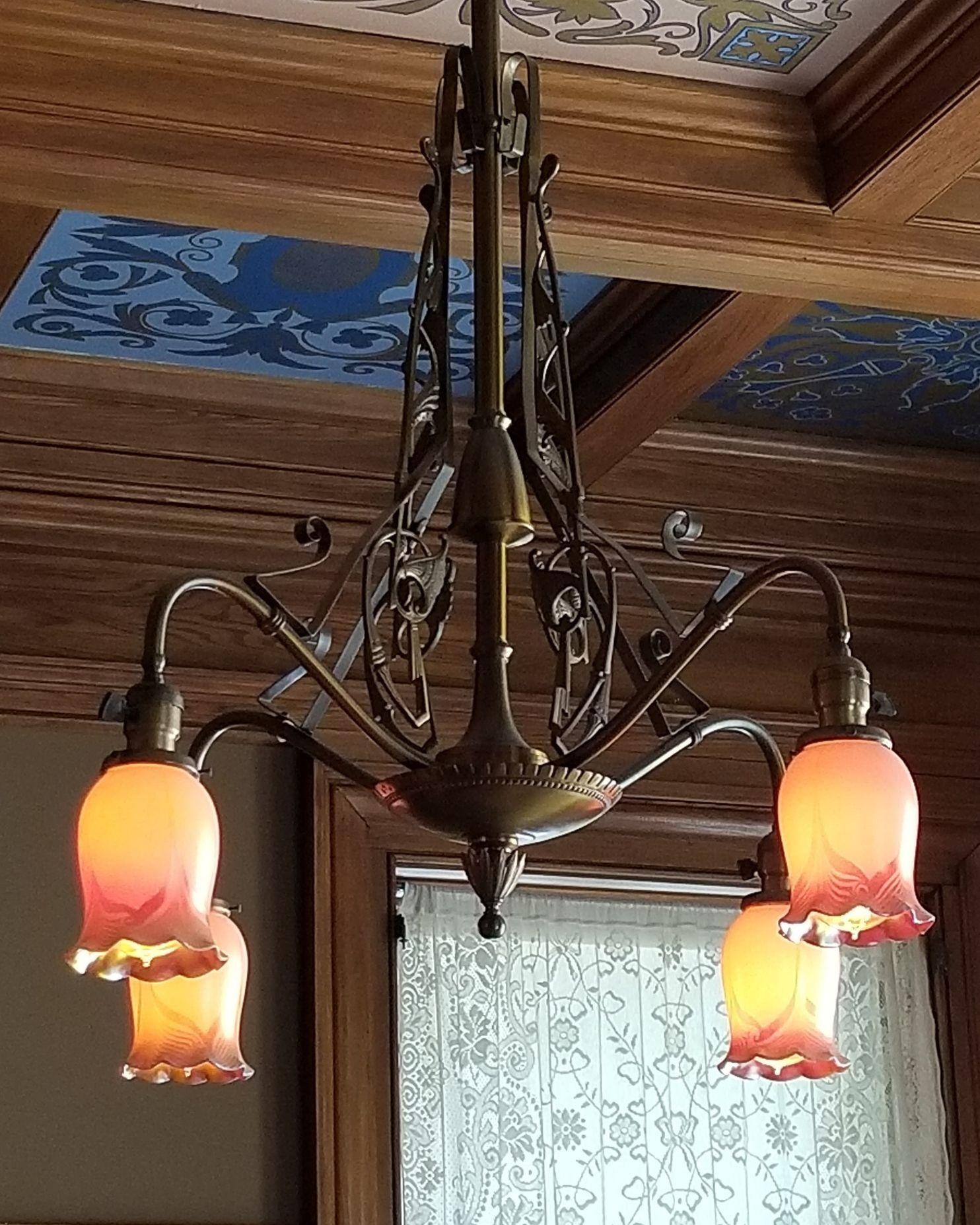 An ornate brass chandelier with four glass diffusers.