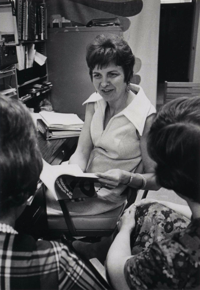 Marge Engelman sits in her office chair talking to students.