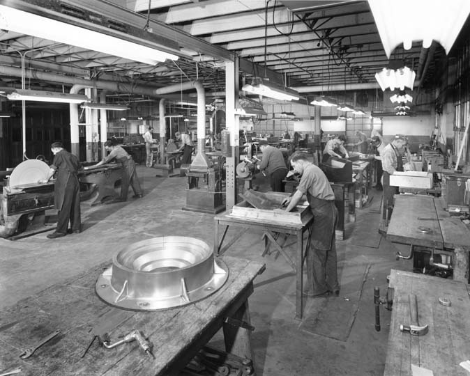 Interior photograph of the pattern shop. A man consults a drawing.