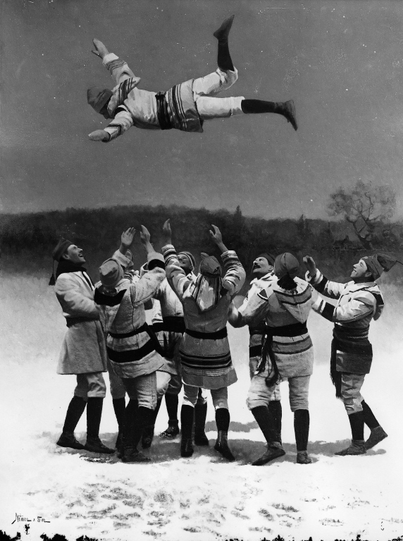 Black and white photograph of a group of people wearing wool jackets throwing another person into the air.