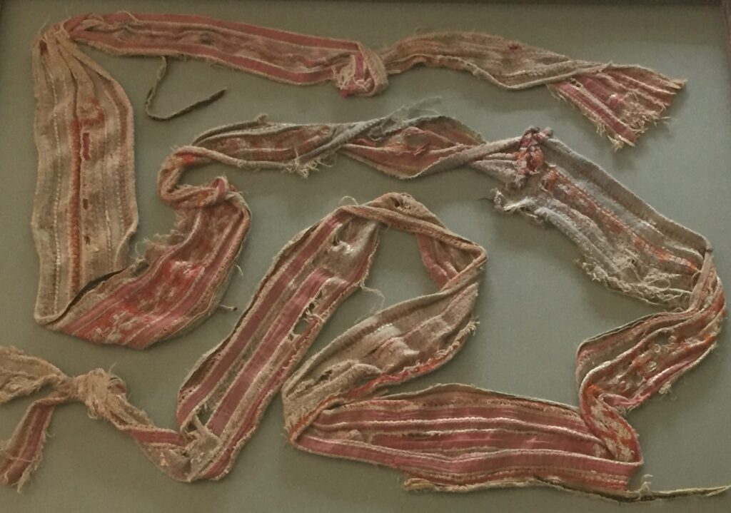 A detailed image of a woven and embroidered baby sash.