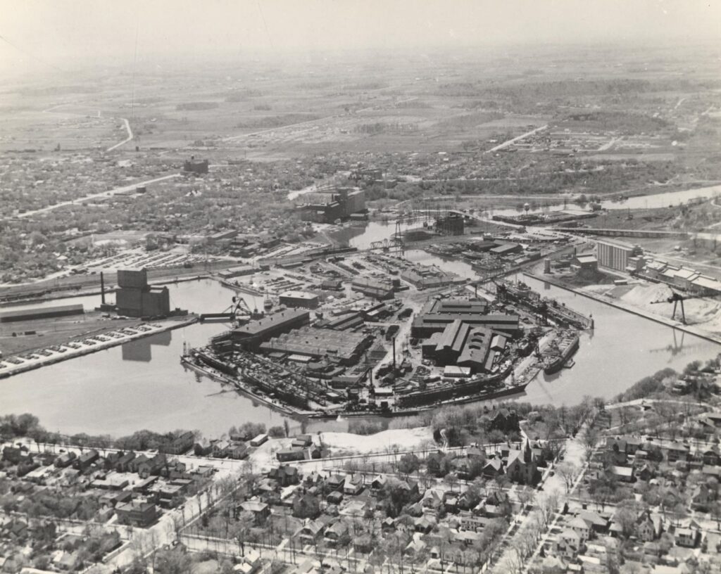 Aerial photograph of a large shipyard on a river.