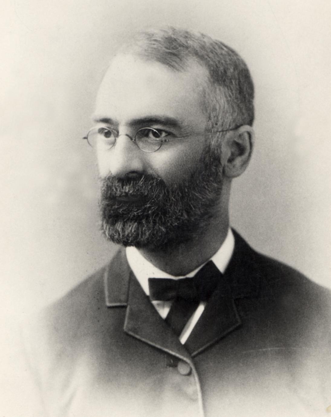 Photographic portrait of a man with beard and glasses.