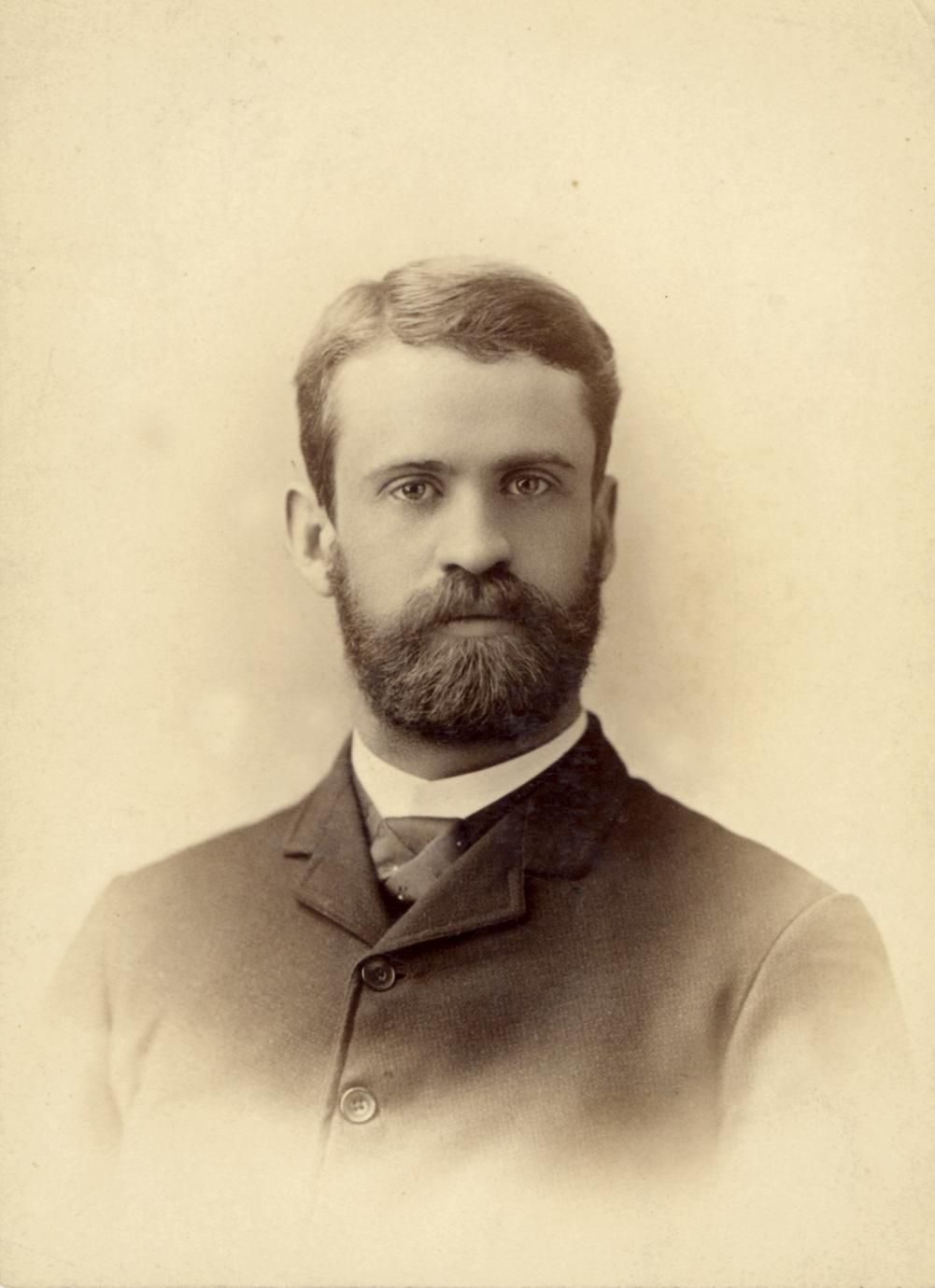 Photographic portrait of a bearded man in a suit.