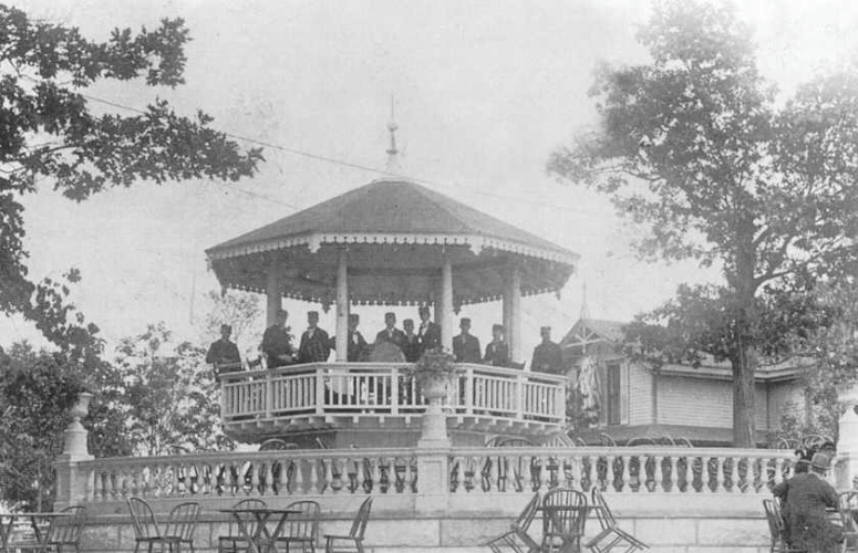 A black-and-white photograph of people posed in an octagonal pavilion.