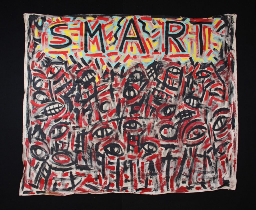 A hand-painted banner with the word 'SMART' painted across the top in black letters outlined in red, blue, and cyan. The rest of the banner is composed of loosely painted and abstracted eyes and teeth.