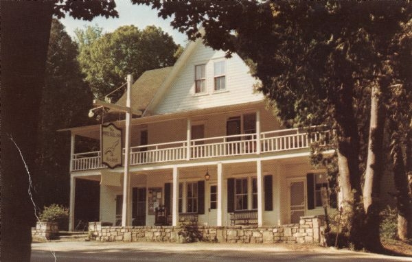 Color photographic postcard of the White Gull Inn. Three entrances are on the porch. A balcony is across the front.