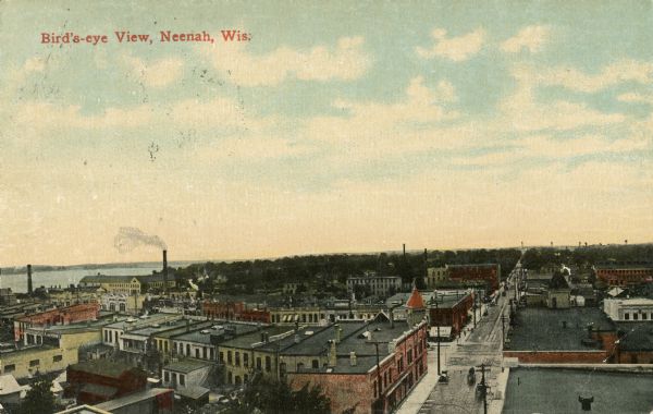 Colorized picture postcard of Neenah, Wisconsin. Elevated view of street and commercial buildings, and neighborhoods and a lake in the background. Caption reads: "Bird's-eye View, Neenah, Wis."