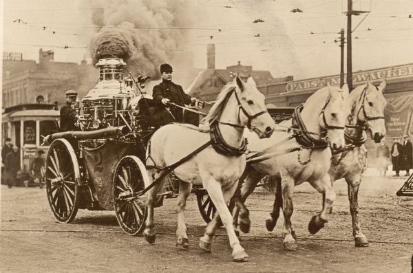 A steam fire engine of Milwaukee's Fire Company #2 drawn by three white horses racing to a fire.