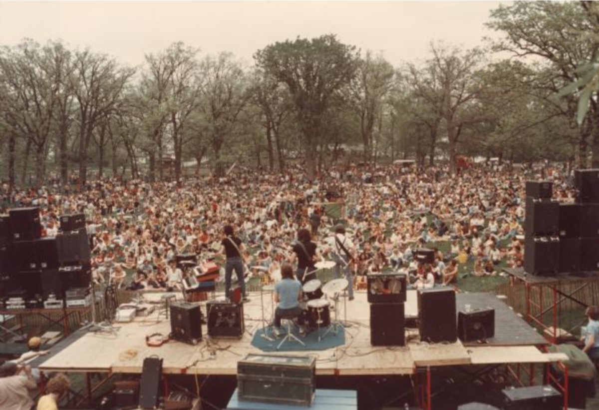 View from above and behind the stage as the band, Spooner, performs to a large crowd at the MadCity Music Festival held at Olin Park, Madison.
