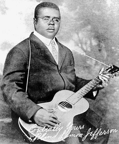 Autographed portrait of Blind Lemon Jefferson posed with his guitar.