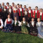 A posed photograph of the 2014 Stoughton Norwegian Dancers. They're dressed in traditional Norwegian costume.