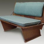 Plywood bench with blue cushions.