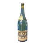 A green glass bottle with worn label reading “Nature’s Purest Drink, The Henk Natural Mineral Spring Water, Waukesha”