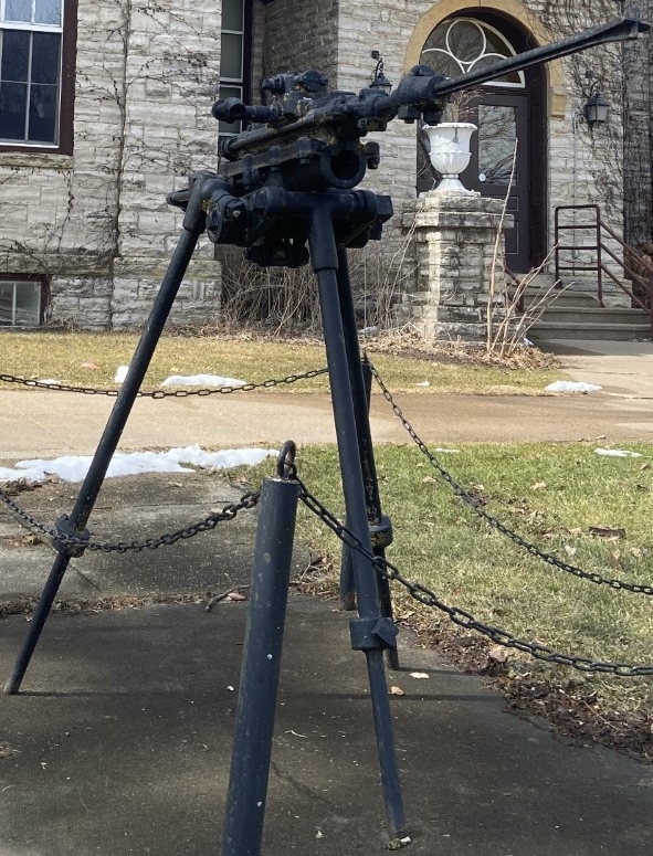 The Ingersoll-Seargent Pneumatic Rock Drill, installed in front of Roundtree Hall in Platteville. It looks like a jackhammer, turned on its side, and mounted to a tripod.