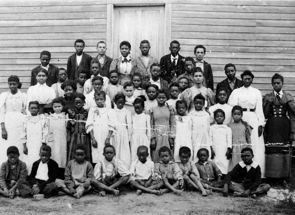 A group portrait of Black settlers in Southeastern Wisconsin, posed in front of what appears to be a rural church.