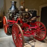 A steam-powered fire engine. An open-frame wagon with a large steam engine that powers a pump to expel water from hoses.