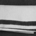 A folded wool blanket with blue stripe.