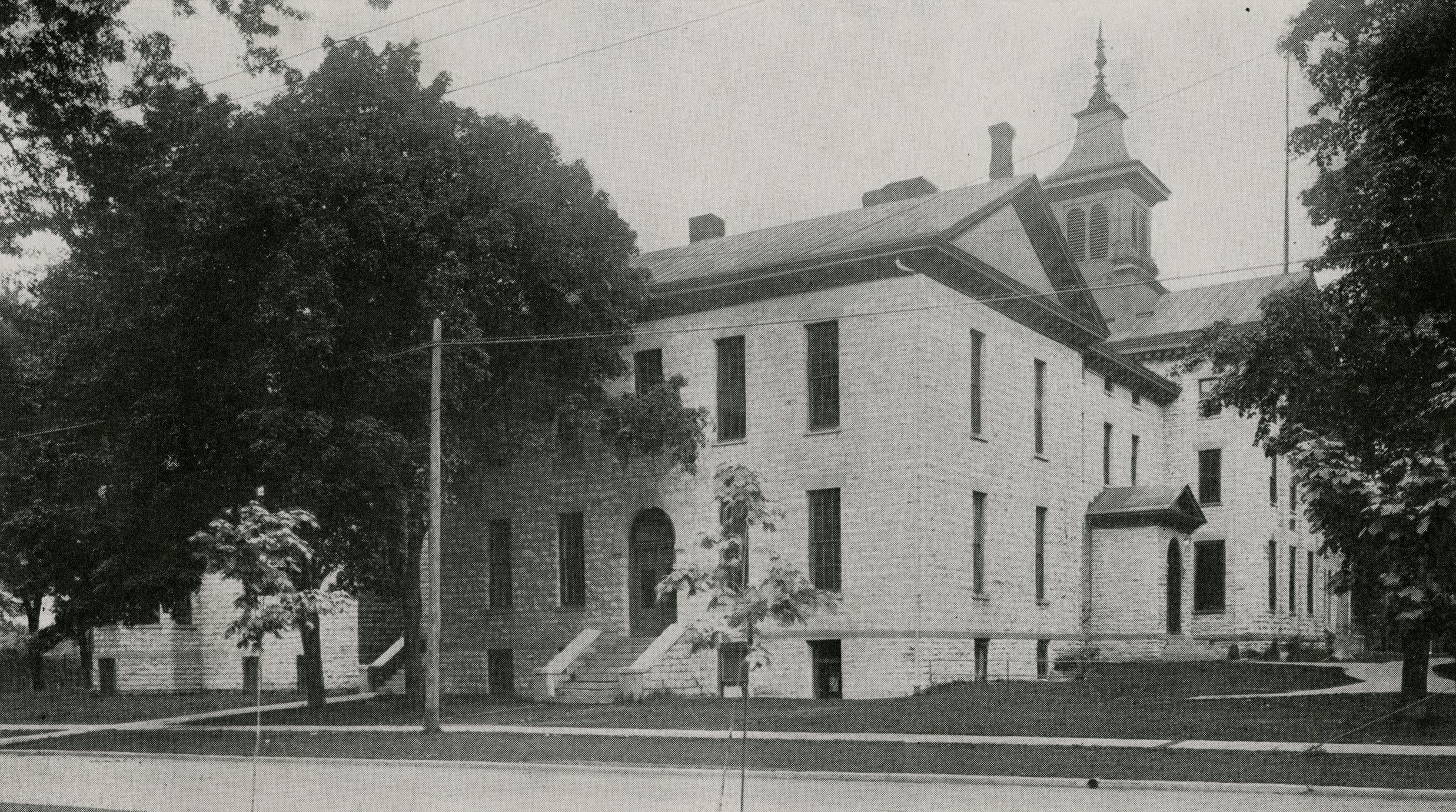 A circa-1920 photograph of a institutional building, constructed of stone.