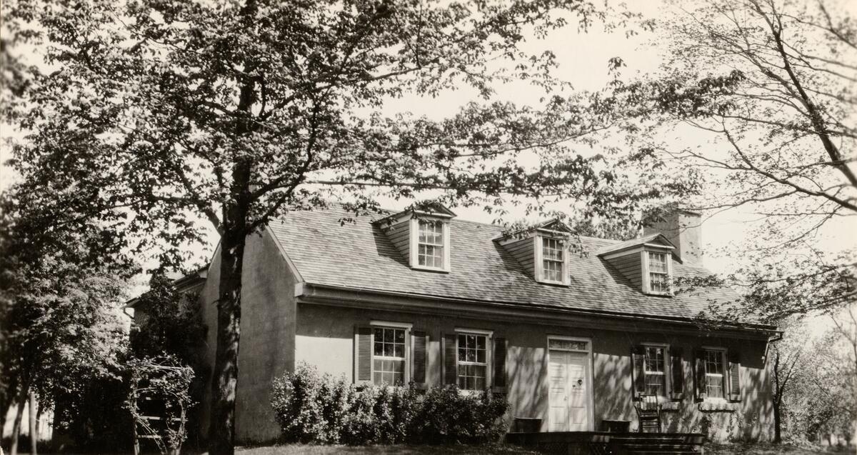 Photograph of a one-and-a-half story stone house.